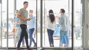 group of young individuals walking through a revolving door
